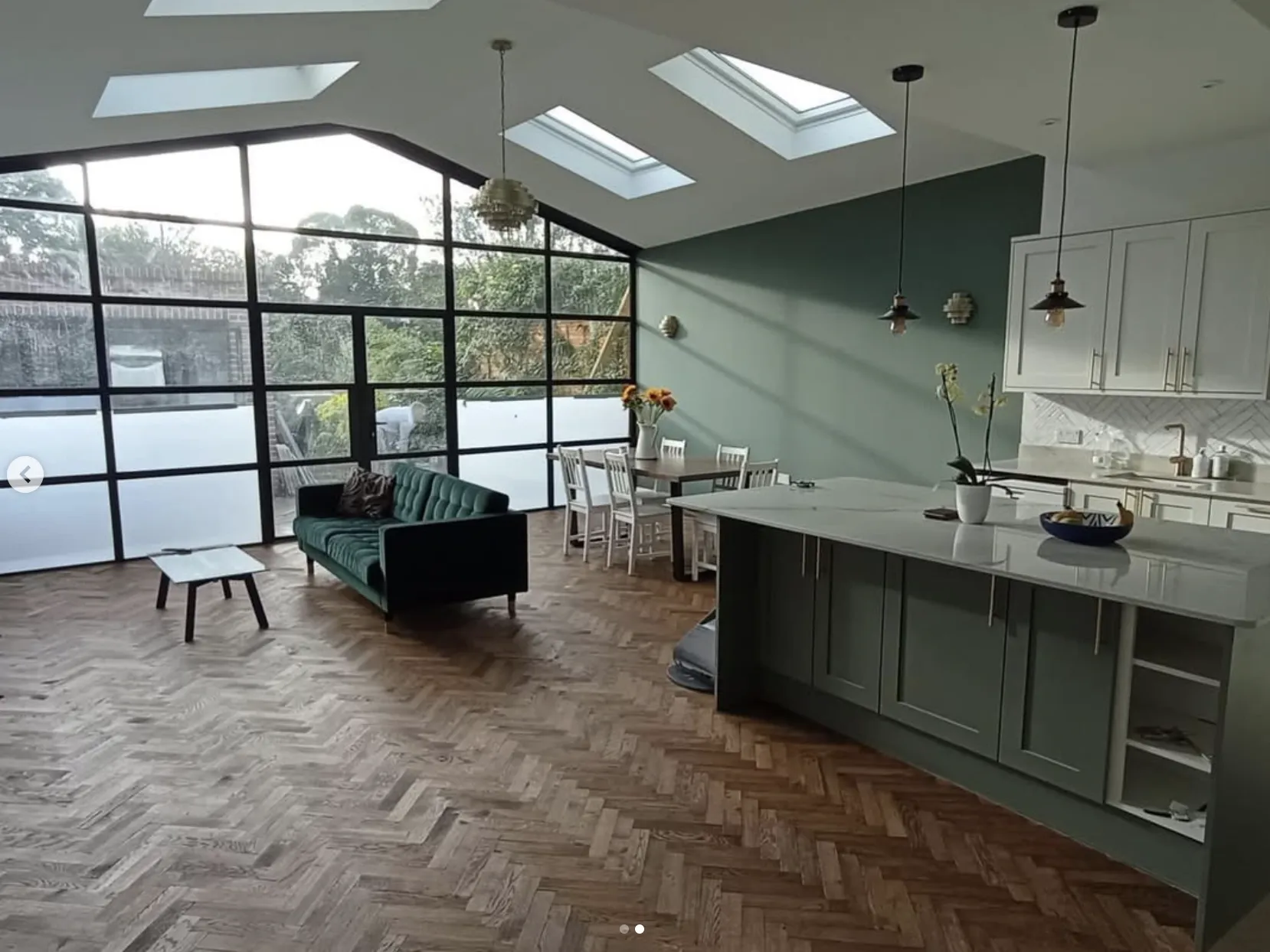 Spacious modern living area with engineered herringbone flooring, large windows, and contemporary furnishings, installed by Woodford Flooring Ltd.