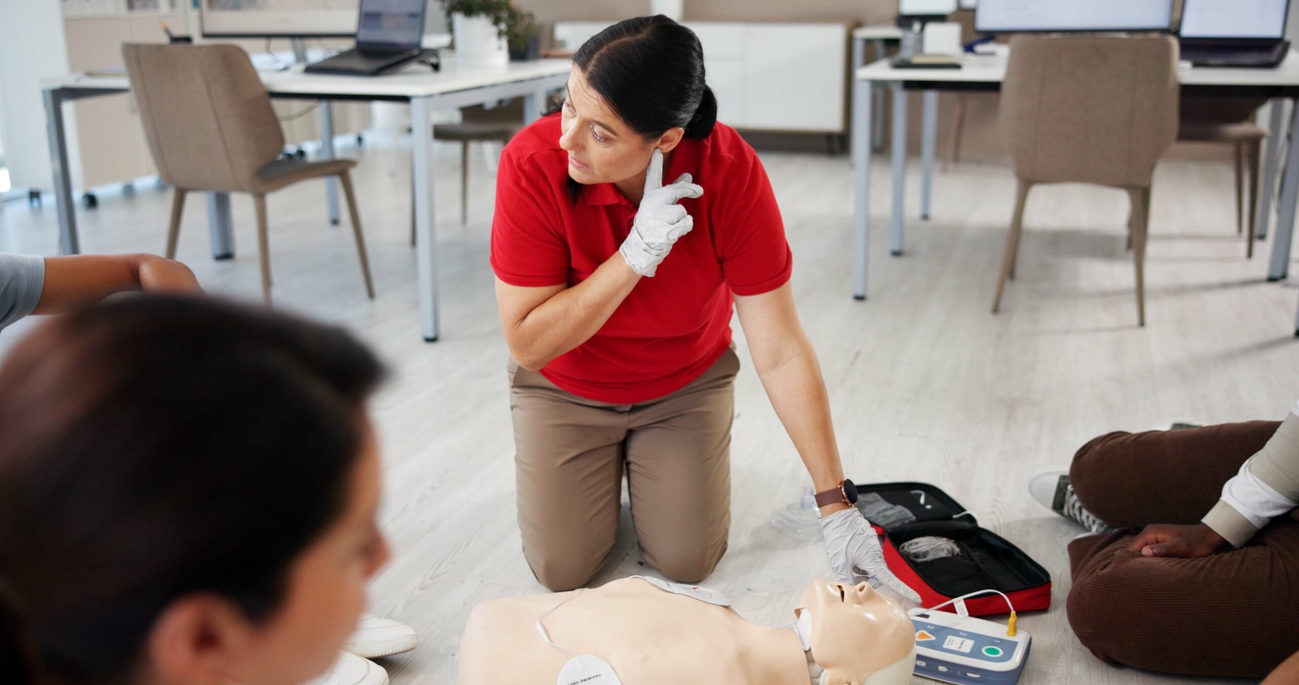 Instructor demonstrating CPR on a mannequin during a {{search_term}} by {{company_name}} in {{place}}.