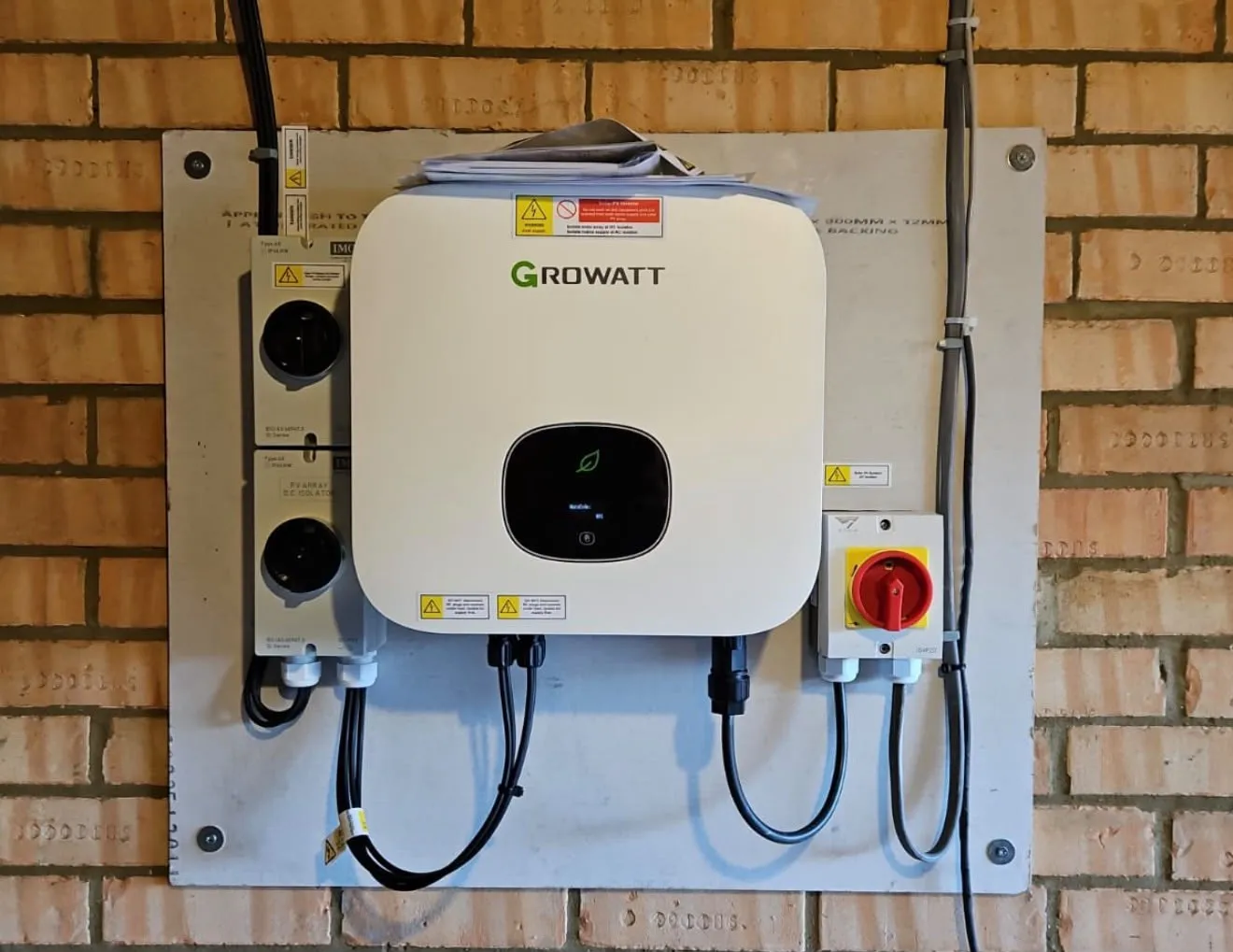 Solar inverter installed on a brick wall, showcasing advanced technology used by ICE Electrical Solutions for Solar Installation in Saffron Walden.