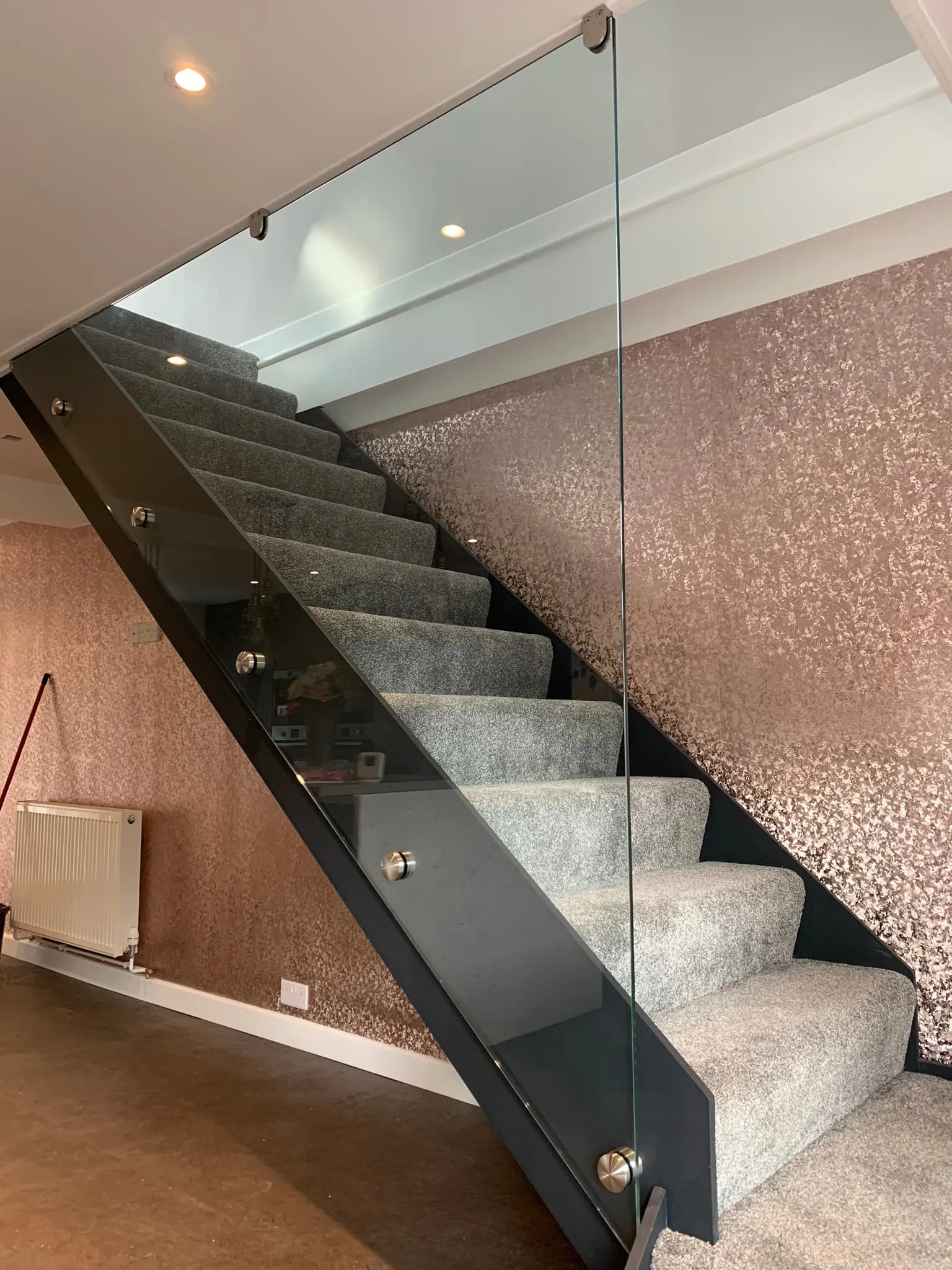 Modern staircase with glass balustrade, showcasing sleek design by FOL Design Ltd for Glass Balustrades &amp; Handrails in Huntingdon.