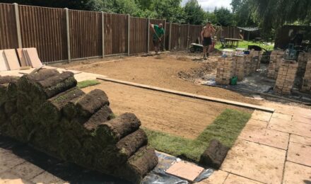 Garden landscaping in progress with turf rolls and workers, illustrating services by {{company_name}} for {{search_term}} in {{place}}.