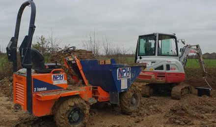 Orange dumper and white excavator on a muddy site, showcasing equipment available for hire from {{company_name}} in {{place}}.