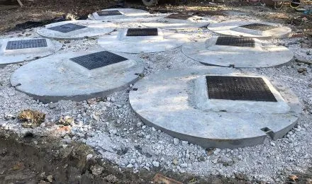 Concrete manhole covers on a construction site, illustrating groundwork services by MJ Digger &amp; Driver Hire Services in St Ives.