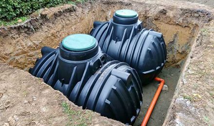 Excavated site with two large black water tanks installed, showcasing groundwork capabilities by {{company_name}} in {{place}}.