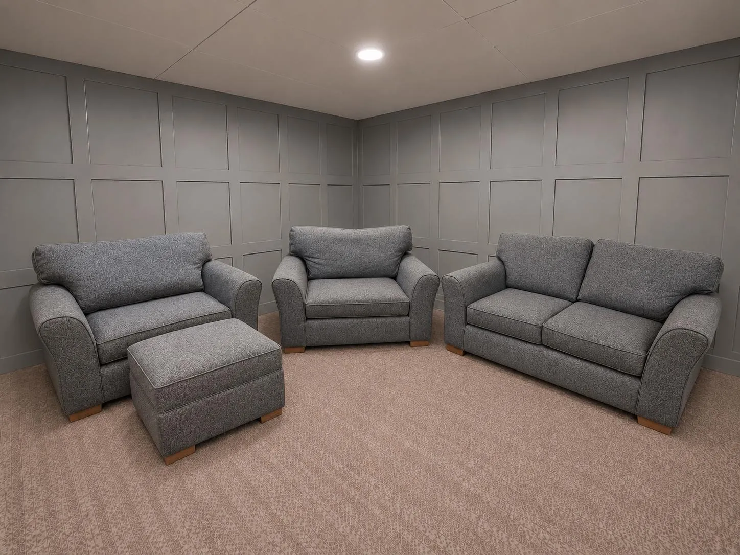 Grey upholstered sofas in a showroom, including two-seater, armchair and three-seater options from Restored Living in Harlow