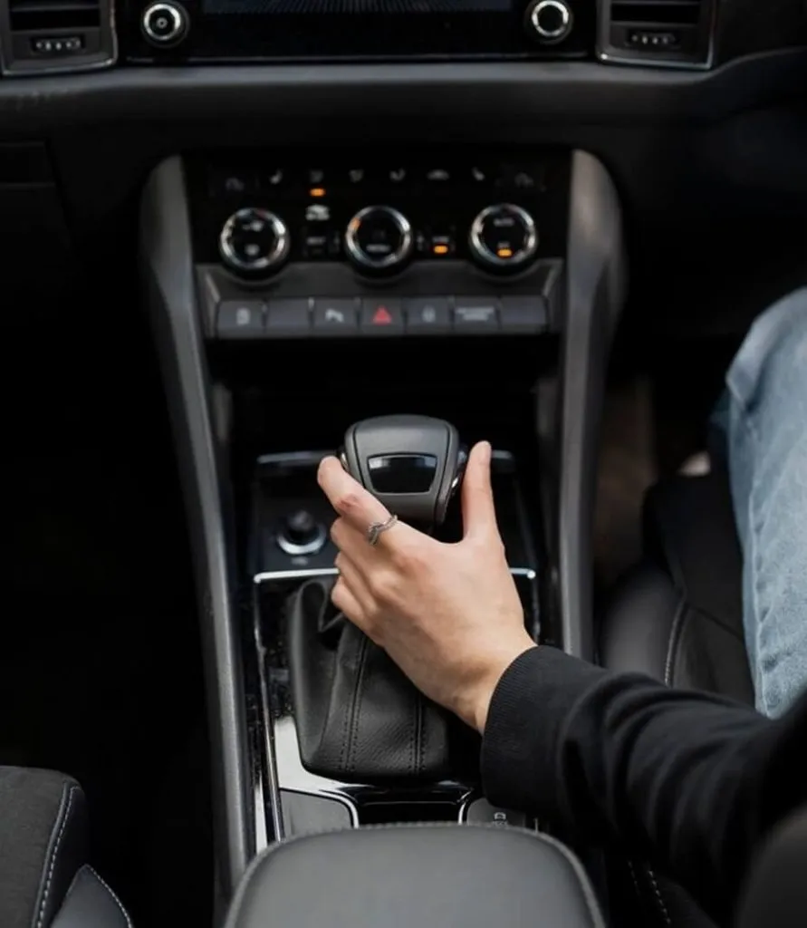 Close-up of a hand on a car gear shift, representing driving lessons offered by Alfie’s Driving School in Clayhall.